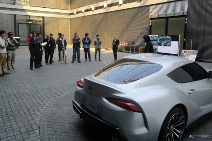 Toyota Supra designers review a scale model in the viewing area