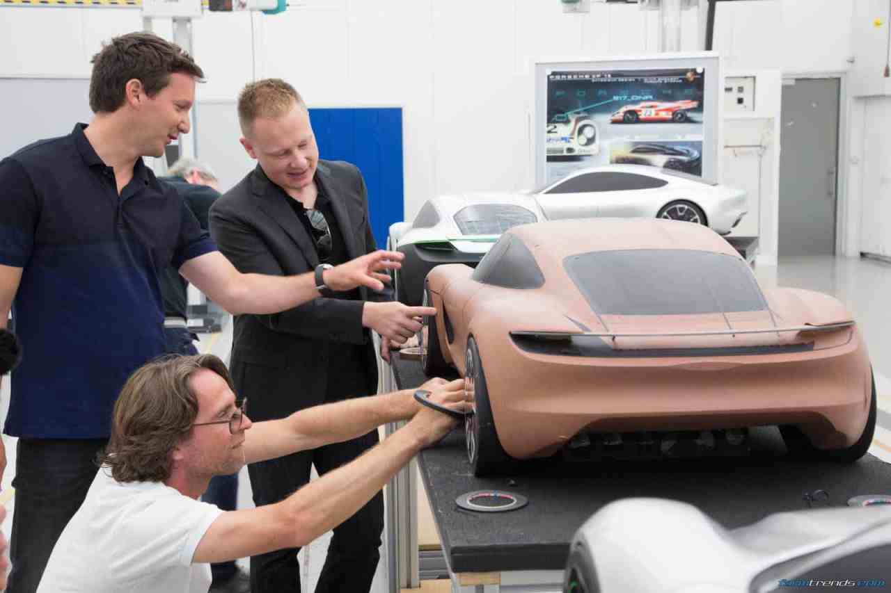 Lead exterior designer Peter Varga (left) looks over a clay model of the Porsche Mission E with exterior designer Emiel Burki and exterior design chief Mitja Borkert